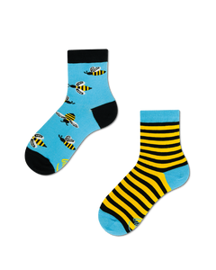 Dwie skarpetki. Jedna we wzór pszczół na niebieskim tle. Druga we wzór żółto-czarnych pasków.