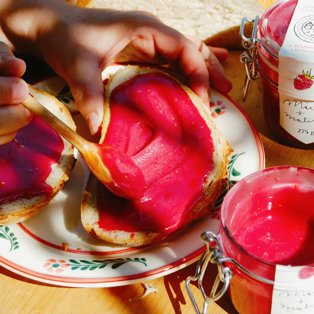 Kromka chleba smarowana miodem z malinami