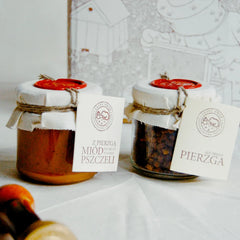 Wypakowane z pudełka prezentowego pierzga pszczela i miód z pierzgą . Wokół słoików ekologiczne pudełko prezentowe z papierową obwolutą.