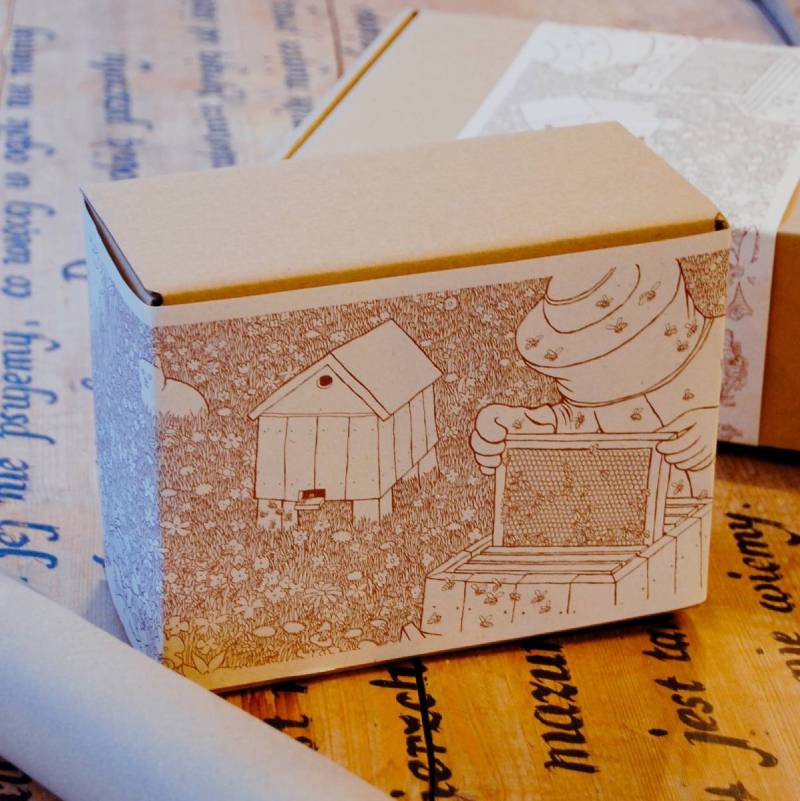 pudełko prezentowe owinięte papierową Miodorowanką: miodową kolorowanką